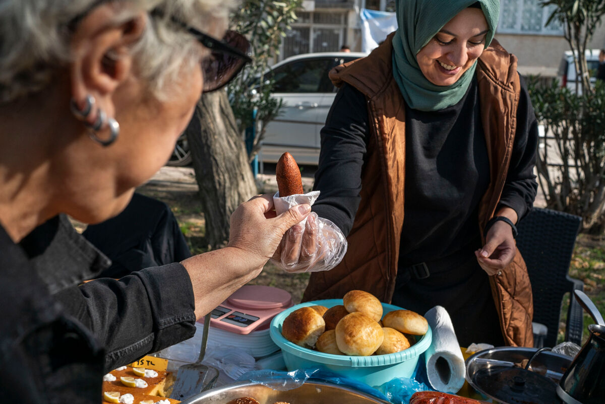 Une cuisiniere du marché des femmes d'Antakya tend un Oruk, sorte de beignet de viande hachée, à une cliente.
